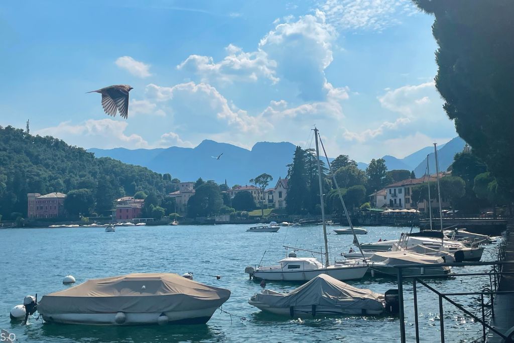 The picturesque village of Lenno on the shores of Lake Como, featuring charming houses, a serene waterfront, and surrounding green hills.