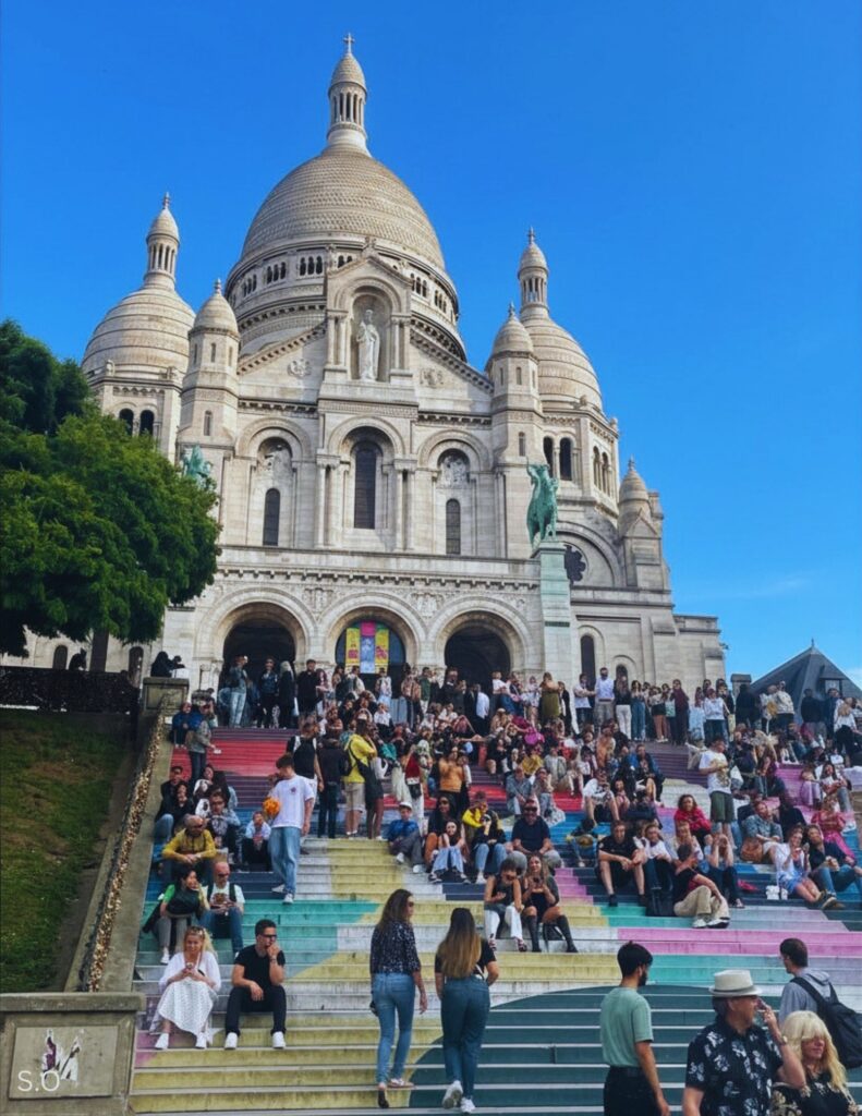The majestic white domes of Sacr&eacute;-C&oelig;ur Basilica perched atop Montmartre, offering panoramic views of Paris.